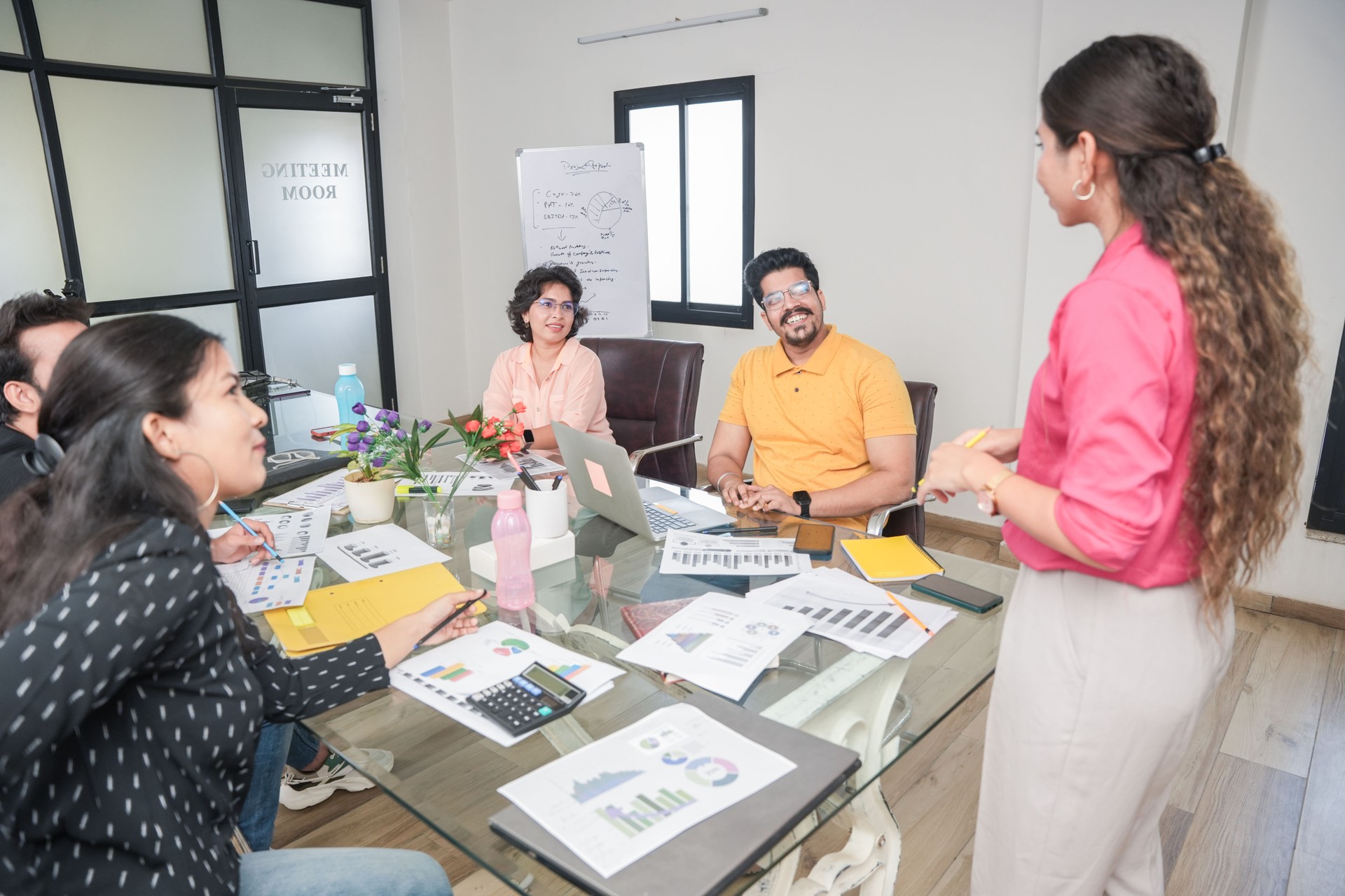 indian woman at office discussing about business project to team members or colleagues in meeting. Start up, leadership, presentation and workplace communication concept. Young Entrepreneur. teamwork